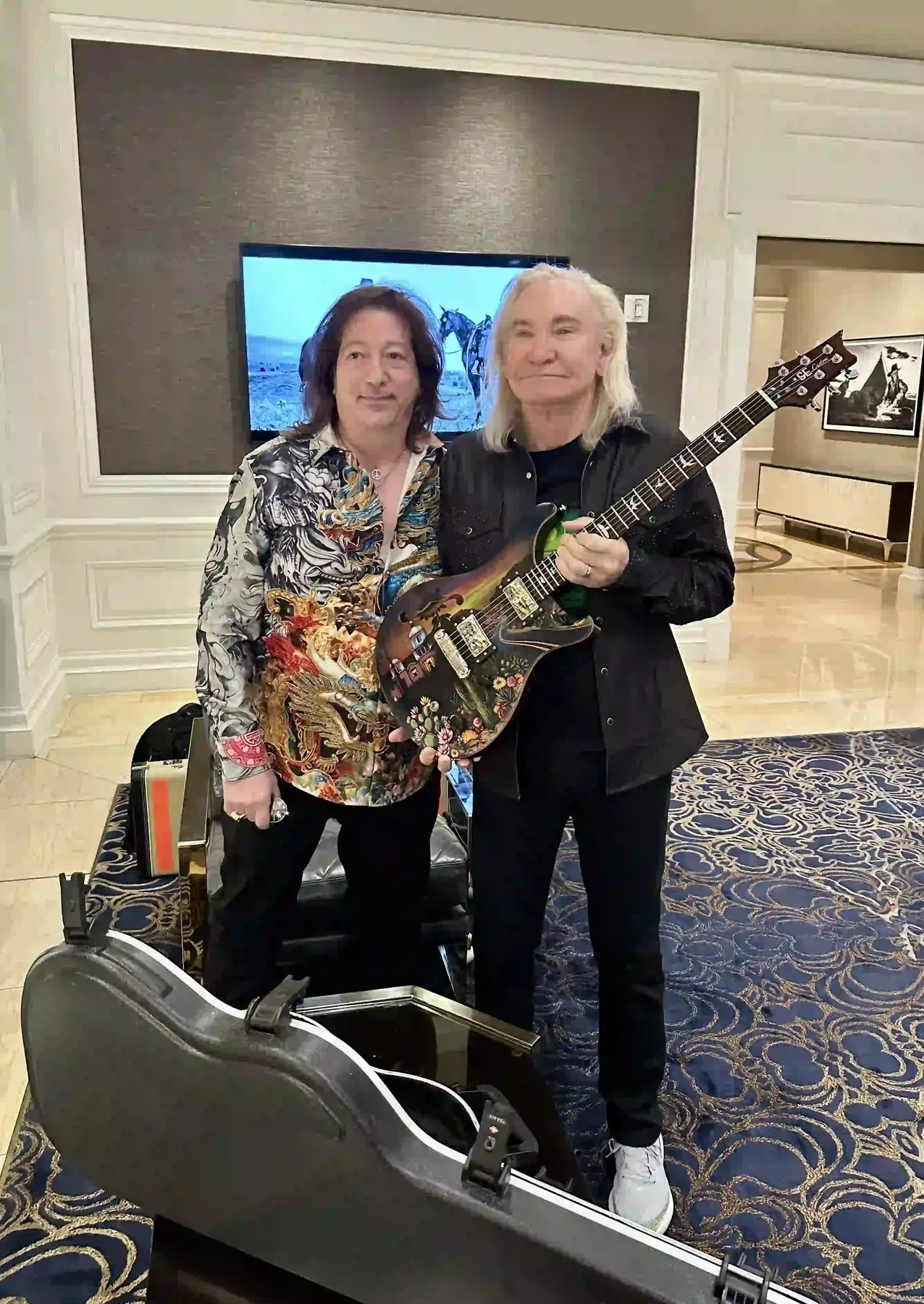 Joe Walsh with Nancy Elhallak's hand-painted PRS Hotel California guitar gift at Animazing Gallery Las Vegas